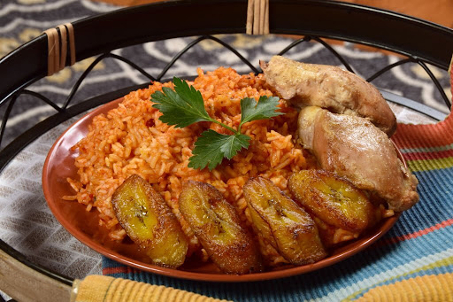 Traditional-West-African-Jollof-rice-with-chicken-seasoned-with-peppers-tomatoes-and-ginger-and-served-with-fried-sweet-plantains-Tasty-Nigerian-Food