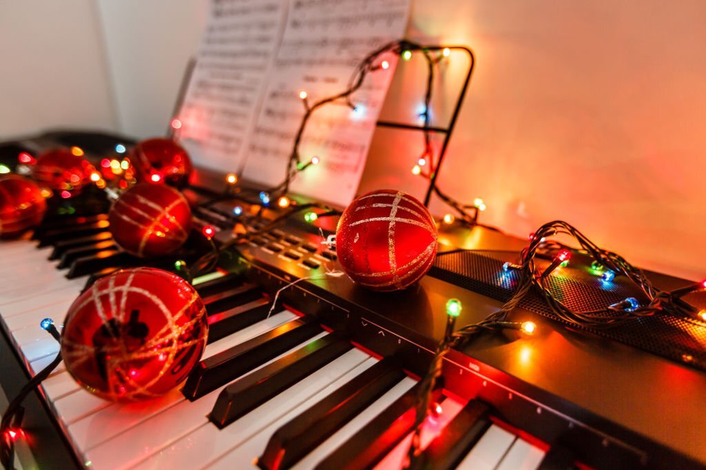 A keyboard with Christmas decoration and an Igbo Hymn book resting on it.