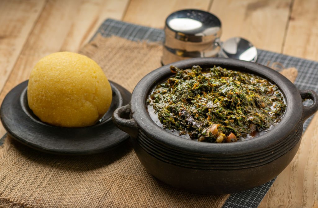 Two bowls on a table, each containing afang soup and Garri