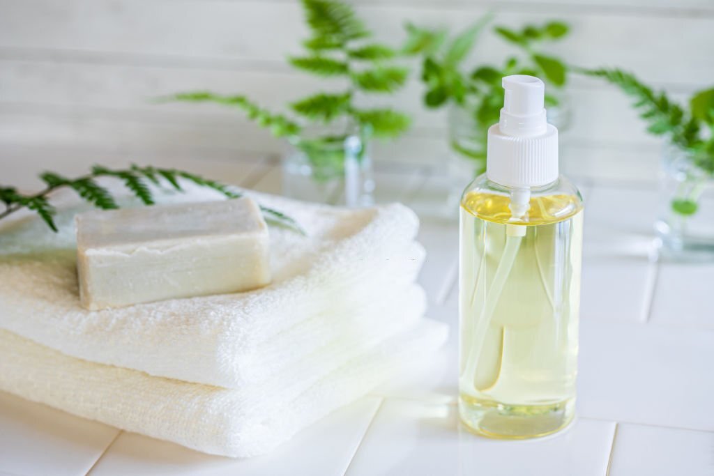 A facial cleanser beside a bar soap