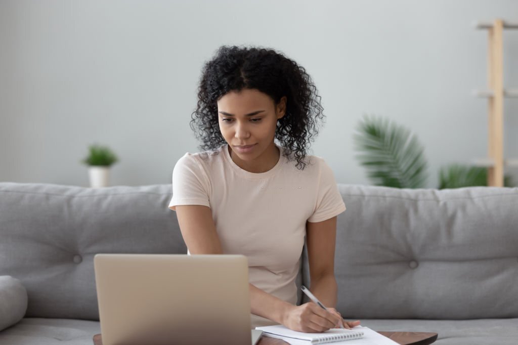 A woman sitting behind her laptop learning tech skills from an online platform