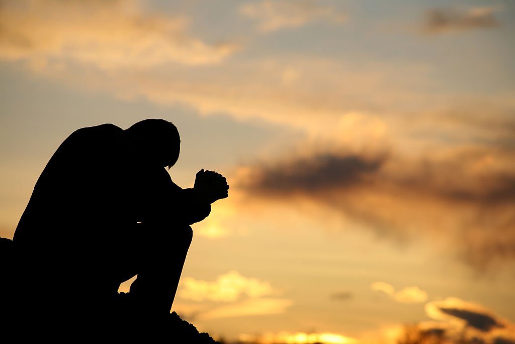 A-man-on-his-keens-praying-at-sunset-modern-and- traditional-hymn